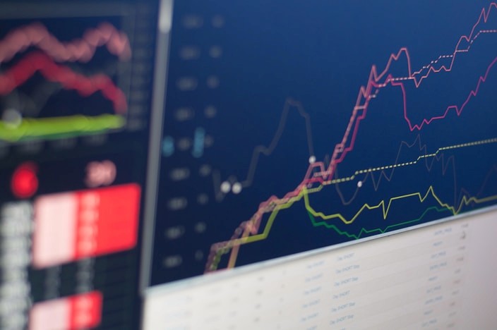 Trading platform with multiple charts on a dark monitor
